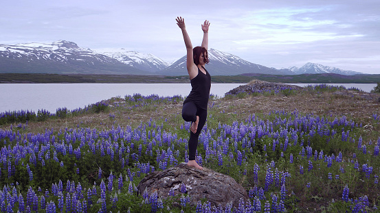 Woman doing yoga surrounded by flowers