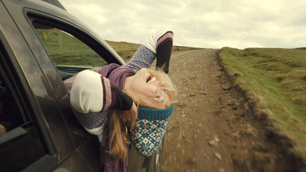 istock Woman leaning out of car window. Wilderness. 1138852111