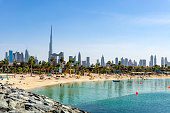 Beach in Dubai with people and skyscapers in the background