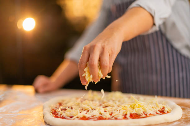 queso en pizza - grated fotografías e imágenes de stock