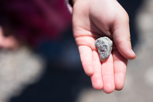 Small child showing off discovered rock in palm of hand