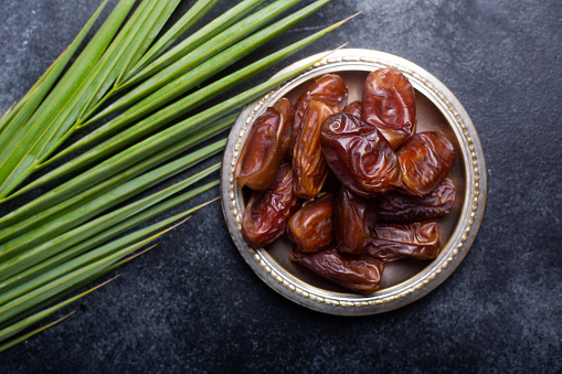 Ramadan dates is traditional food for iftar in islamic world. Dark background