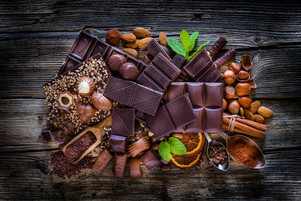istock Chocolate assortment on cocoa powder shot from above on rustic wooden table 1138857259