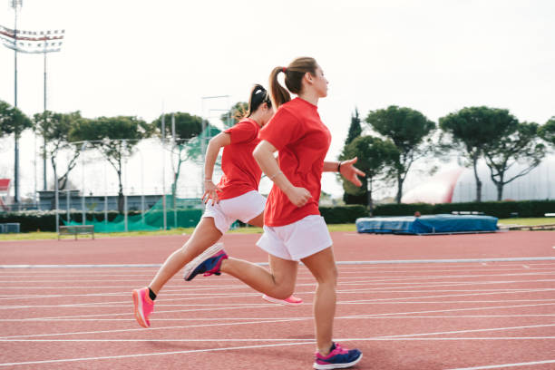 istock Two young women running on race track 1138859114