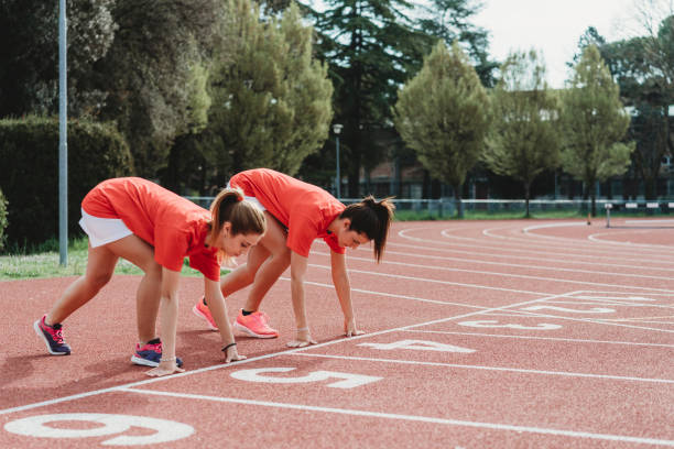 istock Two female runners crouching at starting blocks 1138859116