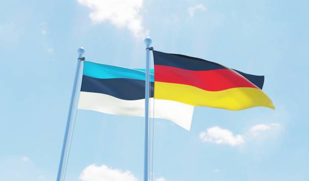 istock Germany and Estonia, two flags waving against blue sky 1138859794