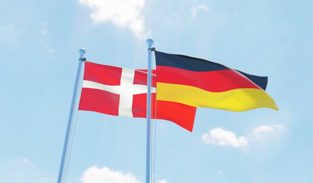 Germany and Denmark, two flags waving against blue sky