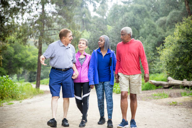 istock Senior Friends Walking on Forest Trail 1138860113