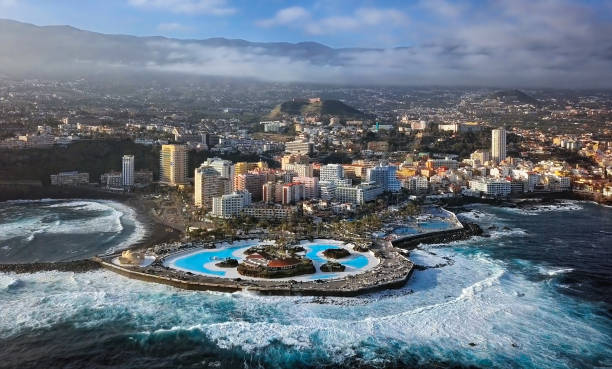 Aerial panorama of Puerto de la Cruz resorts and pools surrounded by sea waves, Tenerife, Canary islands, Spain. Aerial view of Puerto de la Cruz, Tenerife puerto de la cruz tenerife stock pictures, royalty-free photos & images