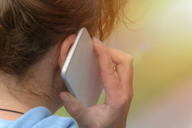 Woman talking on mobile phone, back view