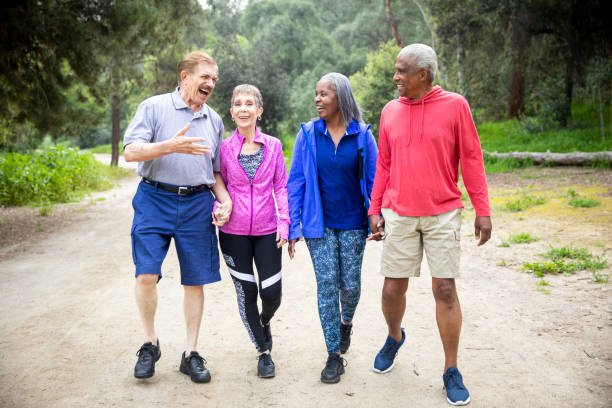 istock Senior Friends Walking on Forest Trail 1138863143