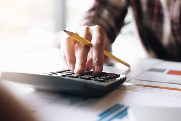 istock Close up Woman pen pointing graph chart in this mounth and use calculator for Plans to improve quality next month. 1138866073