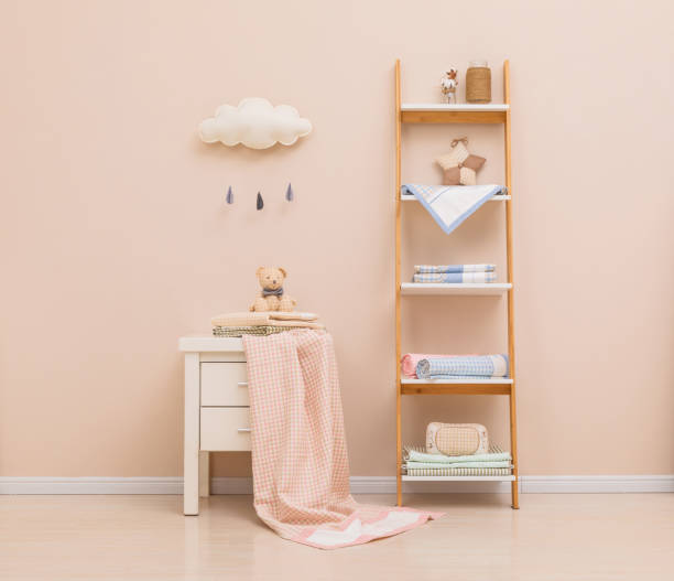 istock Some baby stuff on a white wood, top view. A bib, a pacifier and lilac shoes. 1138866484