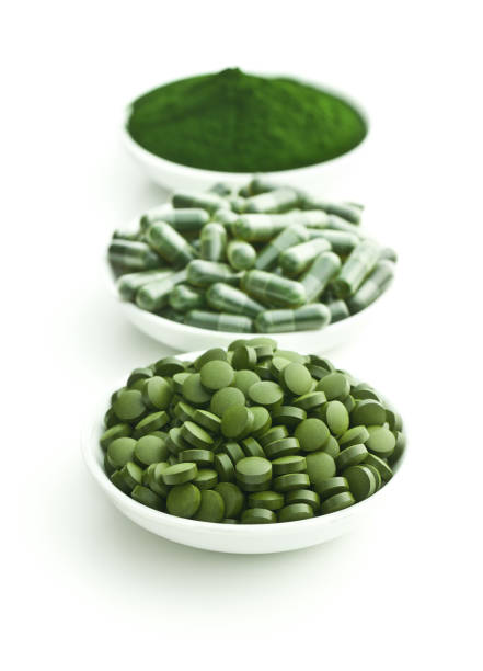 comprimidos verdes do chlorela ou comprimidos verdes da cevada e pó. - spirulina bacterium seaweed food clipping path - fotografias e filmes do acervo