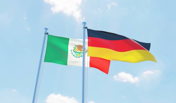 istock Germany and Mexico, two flags waving against blue sky 1138867924