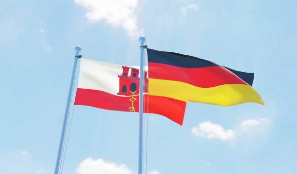 istock Germany and Gibraltar, two flags waving against blue sky 1138868100