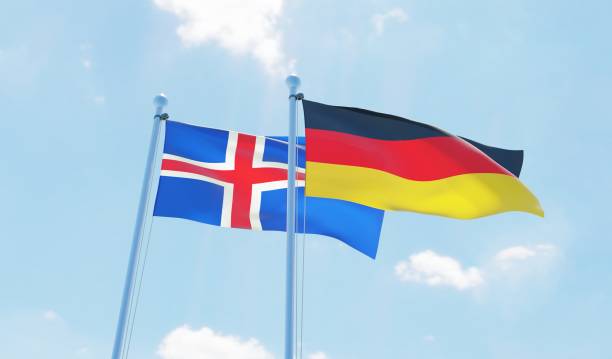 istock Germany and Iceland, two flags waving against blue sky 1138868272