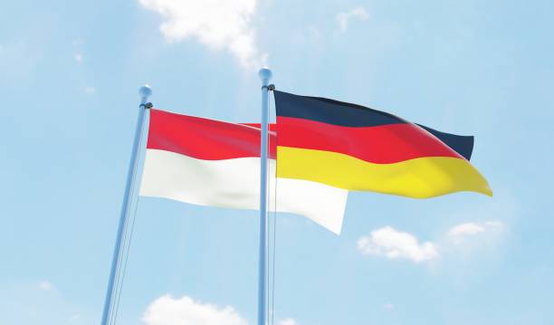 istock Germany and Indonesia, two flags waving against blue sky 1138868280