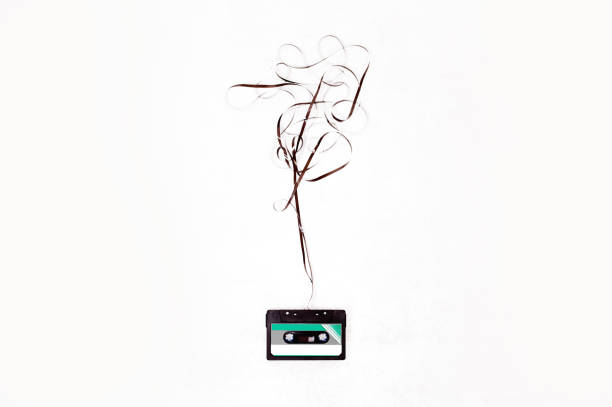 Top view cassette tape over white background with tangled ribbon.