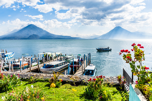 Panajachel, Lake Atitlan, Guatemala - March 8, 2019: Boats, jetties, lake & volcanoes Toliman, Atitlan & San Pedro in Panajachel on Lake Atitlan in Guatemalan highlands.