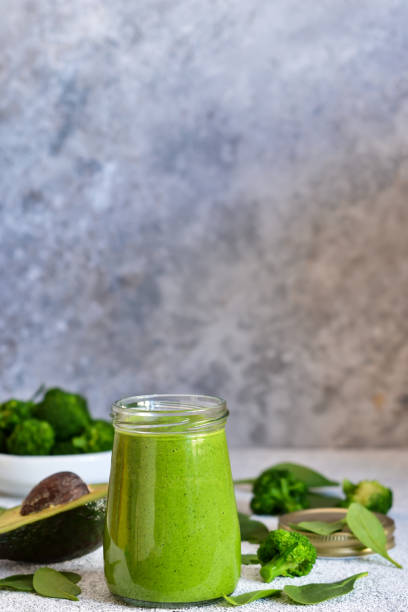 istock Green smoothie with spinach, avocado and broccoli on a concrete background. 1138870436