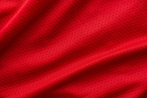 Red fabric sport clothing football jersey with air mesh texture background