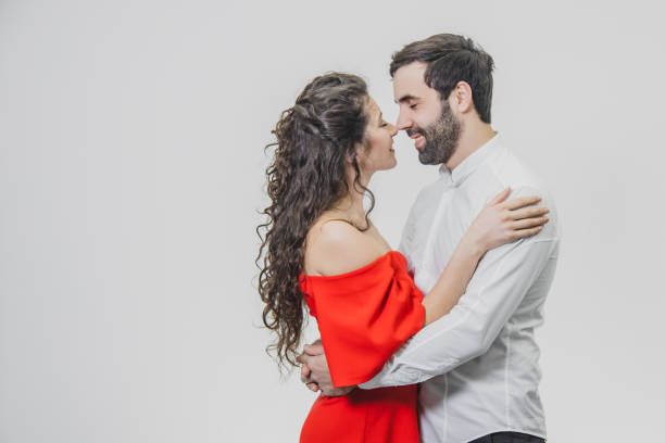a man and a woman with long hair, supporting each other with love. valentine's day. isolated on a white background. a woman dressed in a red dress of a man in a white shirt. - long hair red hair women men imagens e fotografias de stock
