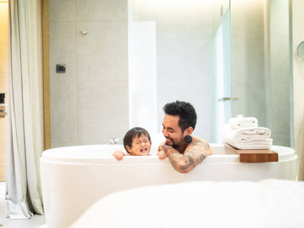 padre asiatico e figlio bambino che si divertono al bagno insieme - tattoo father family son foto e immagini stock
