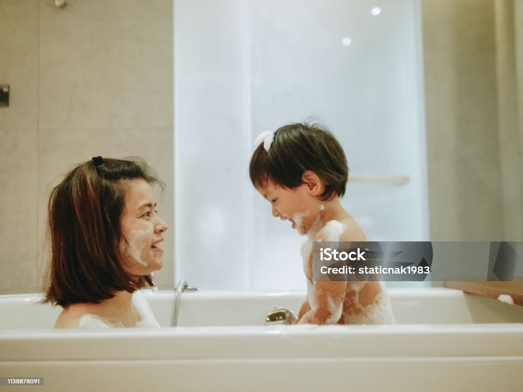 Asian Mother And Baby Son Having Fun At Bath Time Together Stock ...