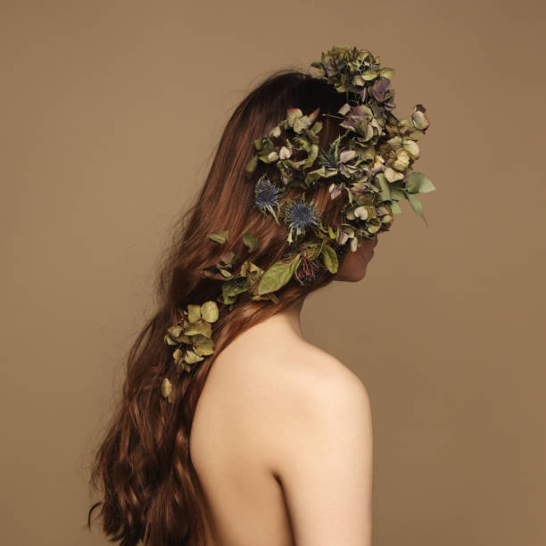 Rear view of young woman and flowers stock photo