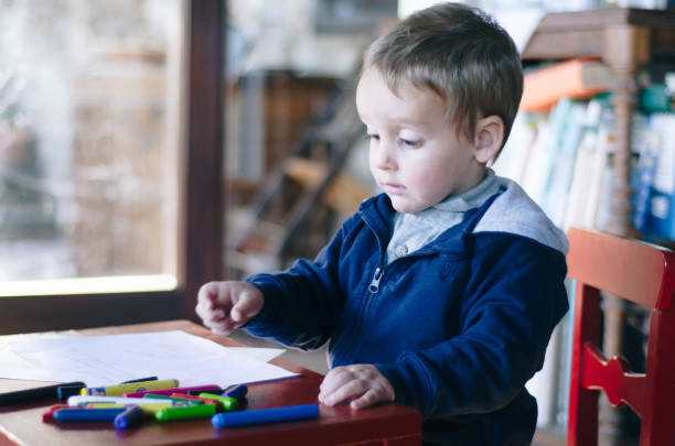 istock Concentrated child painting with colors a drawing 1138880496
