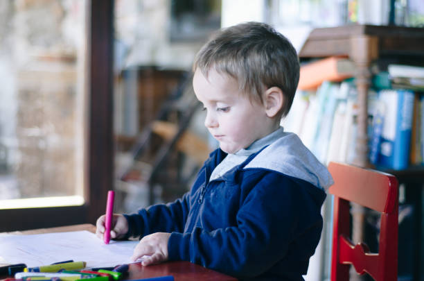 istock Concentrated child painting with colors a drawing 1138880501