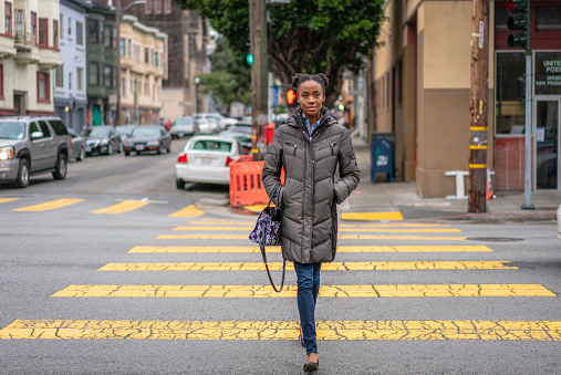 A woman on a crosswalk during winter in San Francisco, California.