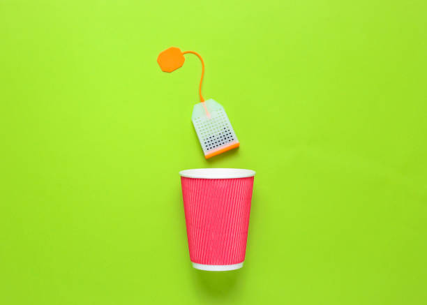 istock Cardboard tea cup and teabag on green background 1138883561