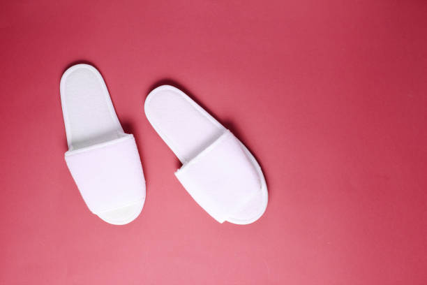 istock White hotel slippers on red background. Top view. Minimalism 1138884197