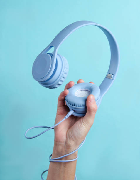Hand wrapped cable holds headphones on blue background