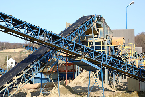 Elements of equipment for the extraction and sorting of rubble. Production of construction materials. Metal construction for working with stone and rocks. Slag of gravel under the conveyor belt.