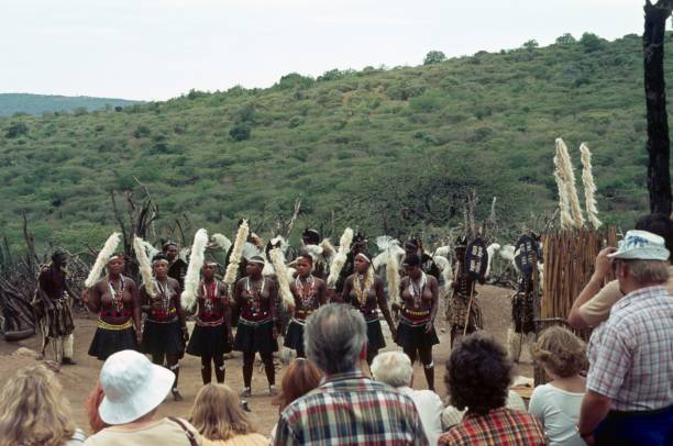 dança das mulheres do tribo zulu na frente de um grupo de turistas, áfrica do sul - zulu african descent africa dancing - fotografias e filmes do acervo