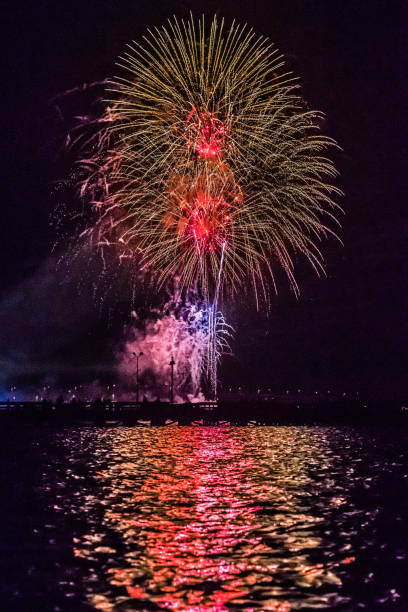 istock Fireworks over the harbor with glowing reflection in the water 1138890104