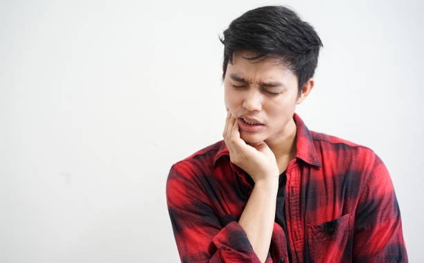 close up asian man using hand massage cheek cause from toothache (wisdom tooth) at house , dental health care concept - dentist pain human teeth toothache imagens e fotografias de stock