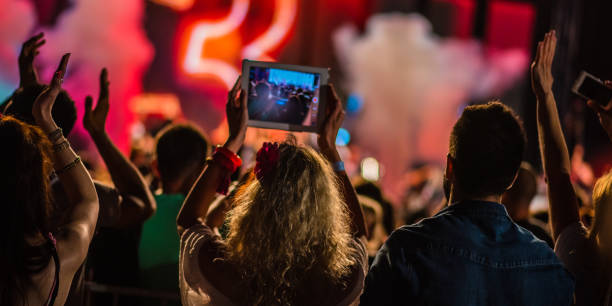 istock Spectator filming a concert with tablet 1138892311