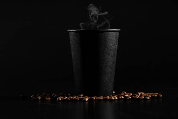 istock A black glass with hot coffee on a dark background. scattered coffee beans. fragrant coffee on the table 1138894875