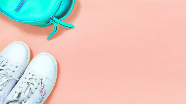 istock Top view White sneakers and turquoise backpak over coral background. Flat lay. Copy space. 1138896328