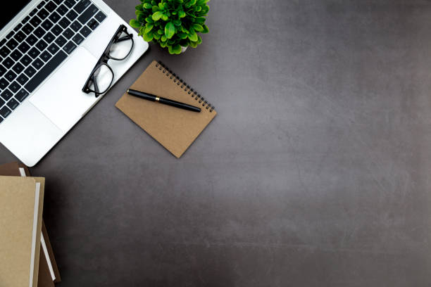 istock Workspace in office ,Black desk with blank notebook and other office supplies,Top view with copy space. 1138897969
