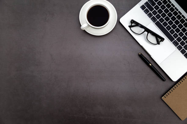 istock Workspace in office ,Black desk with blank notebook and other office supplies,Top view with copy space. 1138898211