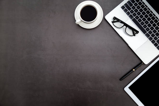 istock Workspace in office ,Black desk with blank notebook and other office supplies,Top view with copy space. 1138898361