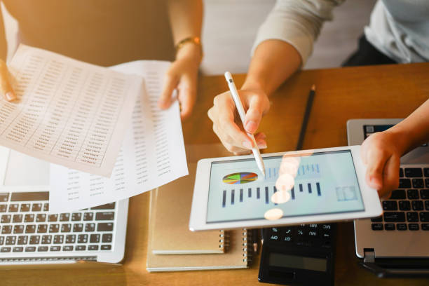 close up group of businessman use stylus pen for explaining dashboard about company's profit monthly on tablet and businesswoman holding report paper for collaborate  work at meeting event , business finance concept close up group of businessman use stylus pen for explaining dashboard about company's profit monthly on tablet and businesswoman holding report paper for collaborate  work at meeting event , business finance concept financial assets stock pictures, royalty-free photos & images