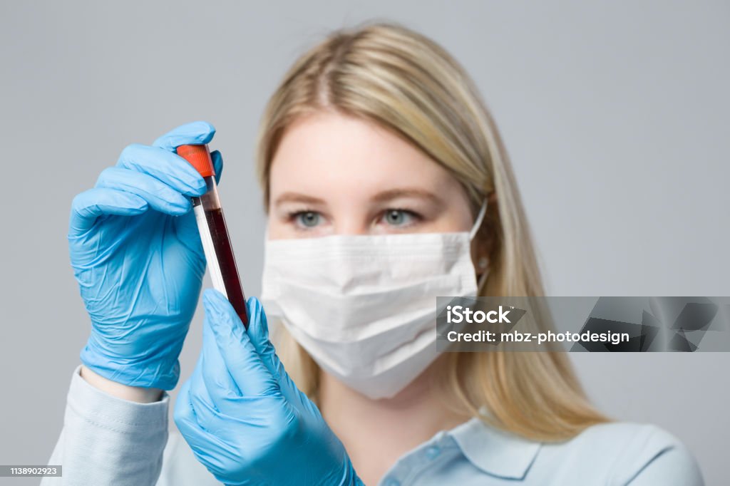 young blonde nurse with medical glove is handling a blood probe Alcohol - Drink Stock Photo