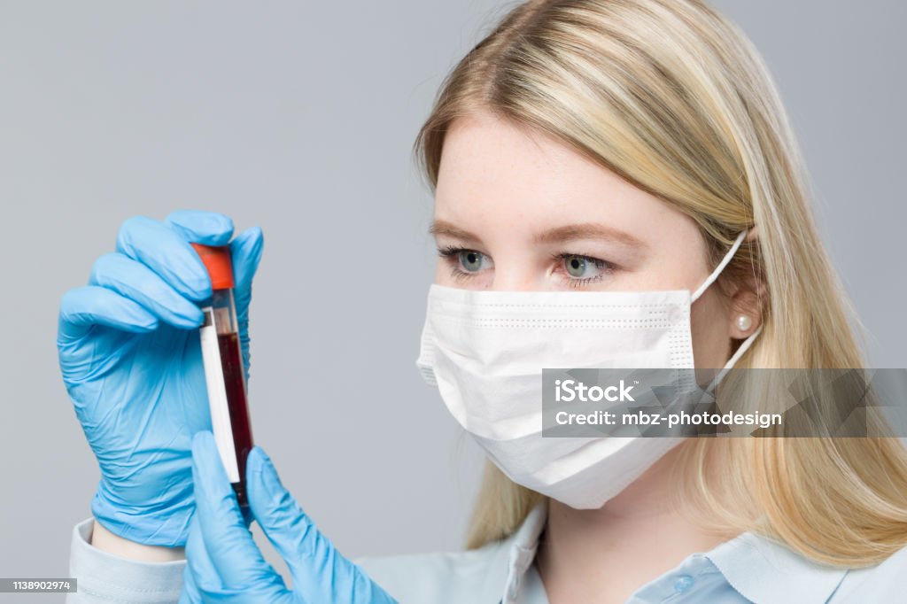 young blonde nurse with medical glove is handling a blood probe Medical Sample Stock Photo