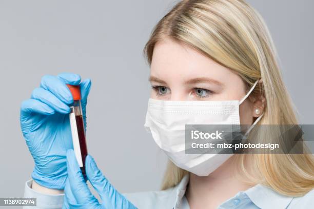 Young Blonde Nurse With Medical Glove Is Handling A Blood Probe Stock Photo - Download Image Now